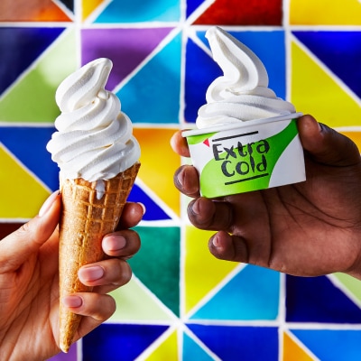 Hands holding Nando's Bottomless Soft Serve Ice Cream in cone and tub